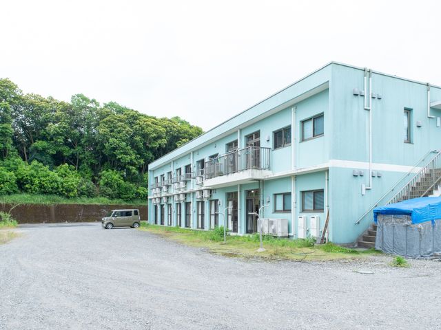 青い壁の建物外観 外観 自然に囲まれた落ち着いた雰囲気の外観です。働くスタッフも心地よい環境でお迎えいたします。