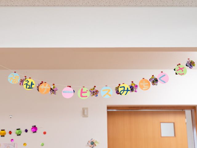 彩り豊かな装飾ガーランド 装飾 にぎやかな文字が描かれたガーランドが、温かな雰囲気の室内を彩っており、訪れる方々への明るい歓迎の意を表しています。