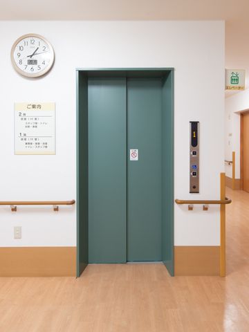 明るい廊下のエレベーター エレベーター 床から天井までクリーンな印象のエレベーター前です。手すりが備え付けられ、安全に配慮された設計になっています。