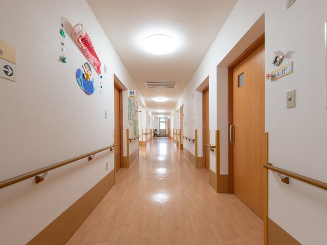 清潔な廊下の風景 廊下 手すりが設けられた温かみのある廊下です。壁には季節感を感じさせる装飾が施され、訪れる方々に安らぎを提供します。
