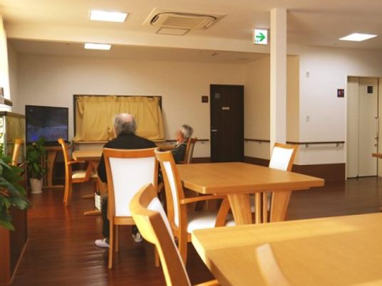 室内にはテーブルと椅子がいくつか置かれ、奥にはキッチンカウンターが見える。食堂として使われる他、談話スペースにもなっている。