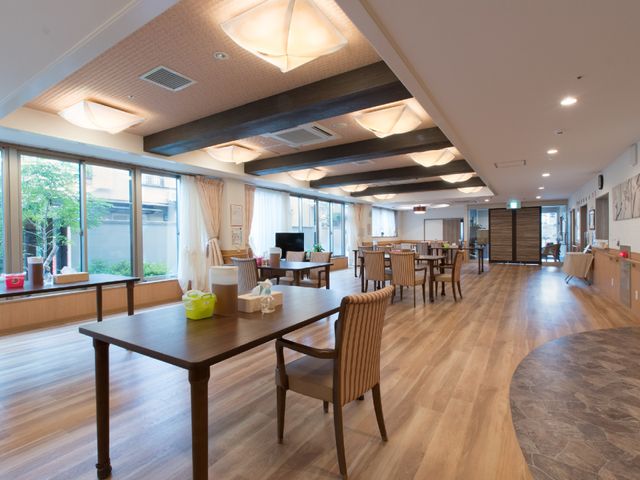 居心地の良い食堂空間 大リビング 広々とした木の温もりを感じる食堂で、一緒に働くスタッフとのコミュニケーションも楽しめます。窓から自然光が差し込むリラックスできる環境です。