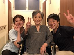 笑顔でポーズを取るスタッフと利用者