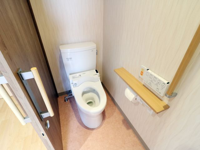 バリアフリートイレ設備 トイレ 手すり付きの清潔なトイレです。機能的な設計により、どなたでも利用しやすくなっています。