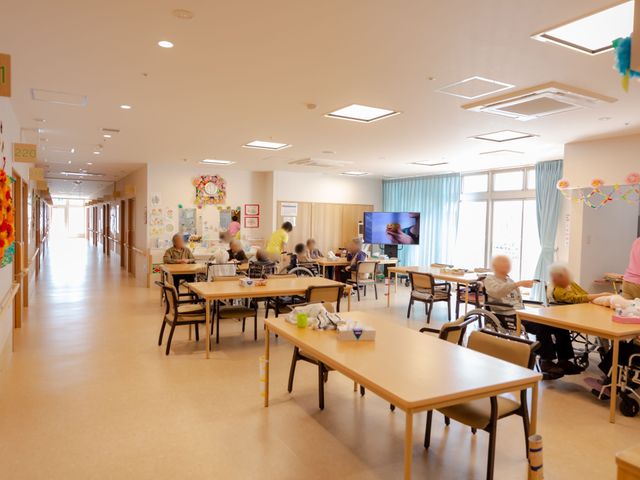 活気ある共有スペース 食堂 ゆったりしたダイニングで利用者が憩い、テレビを見ながら過ごす様子が見られます。働く上でこんな明るい環境がお待ちしています。