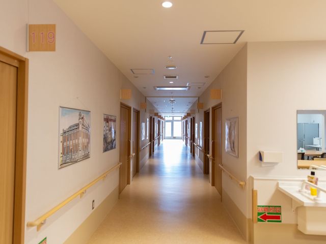 廊下と部屋番号 洗面スペース くつろげる廊下には、部屋番号が明示され、落ち着いた色合いの壁にアートが飾られています。ゆったり歩行できる広々設計です。