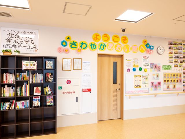 多彩な掲示物のあるロビー ロビー 温かみのあるロビーがお出迎えします。様々な情報をご提供する掲示板と図書スペースがあり、利用者の方々の交流の場として機能しています。