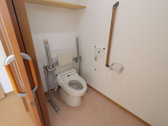 施設の写真 白壁の清潔感のある居室トイレの様子。緊急時に呼出ボタンを押すと、ただちにスタッフが対応してくれるので安心である。