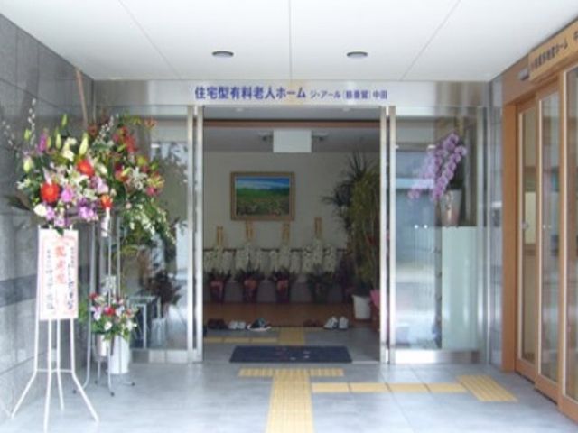 花で飾られた施設入口 エントランス 暖かい印象を与えるエントランスです。お花が明るい歓迎の気持ちを表しています。