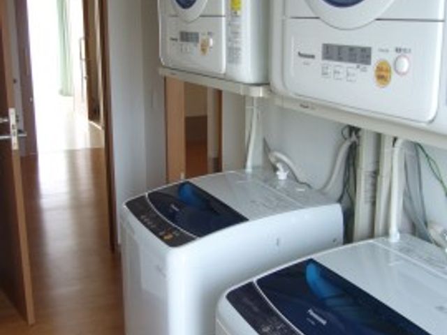 洗濯機と乾燥機の設備 洗濯室 清潔に保たれた洗濯設備が完備されており、快適な生活サポート体制が整っています。
