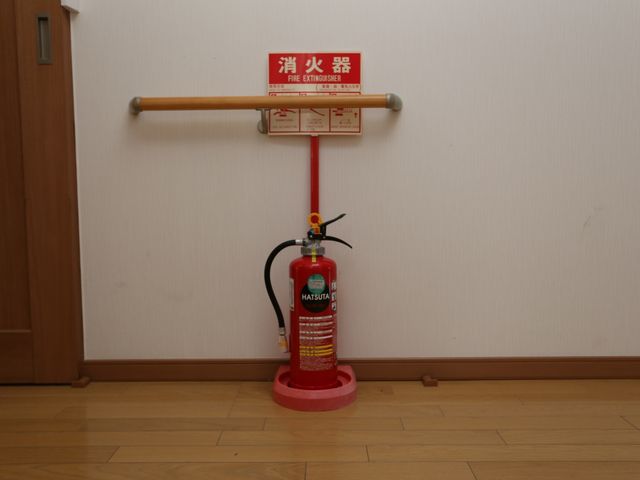 消火器と誘導標識のある廊下 廊下 廊下に備え付けられた消火器は、安全確保のために整備されており、職員も緊急時の対応に備えて日々訓練を積んでいます。