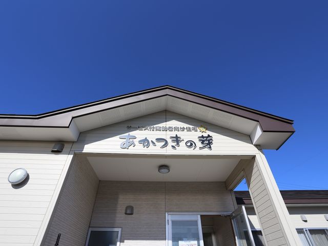 施設外観の入口 外観 心地よい青空の下、清潔感のあるエントランスが迎えます。明るく安心の雰囲気を感じさせる環境がここにあります。