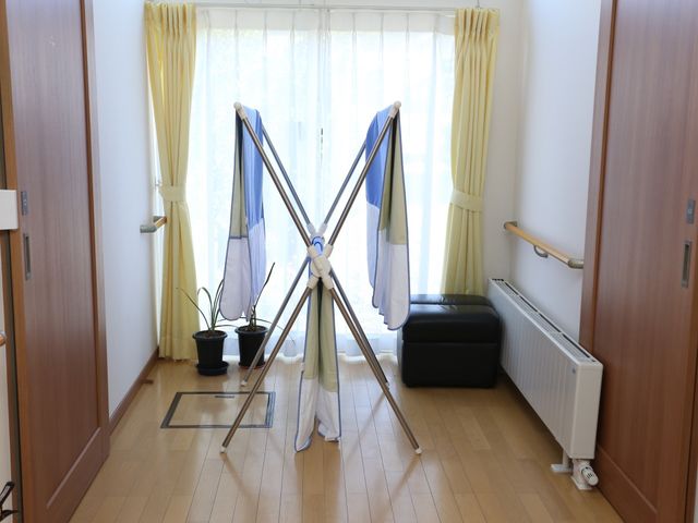 明るい居室の洗濯物干し 廊下 ゆったりとした居室には、日当たりが良く、窓際で洗濯物が乾かせる環境が整っていることがうかがえます。