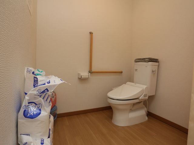 手すり付きのトイレ空間 トイレ 手すりが設置された清潔なトイレです。利用者の安全を考慮したバリアフリー設計になっており、快適にご使用いただけます。