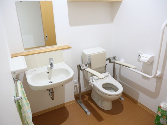 手すり付き清潔なトイレ トイレ 安全に配慮されたデザインのトイレです。手すりがあるため、サポートが必要な方にも使いやすく工夫されています。