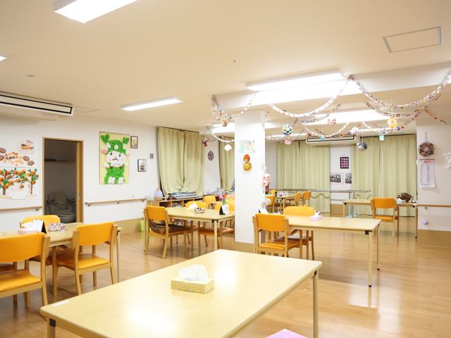 和やかな共有空間 食堂 明るく広々とした食堂は、季節感のあふれる装飾が施され、訪れる人の憩いの場となっています。木製のテーブルや椅子が並び、温かみのある空間で職員とのふれあいが生まれます。