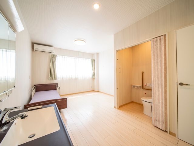 広々とした明るい居室 居室 清潔感ある居室で、床のバリアフリー設計が協力的な職場を実現しています。日当たりの良い窓辺で、ゆとりあるケアに専念できそうです。