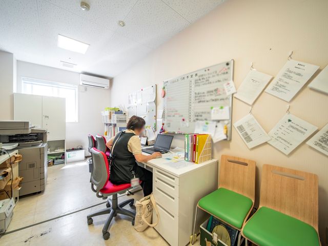 事務作業する人のオフィス 事務室 整理整頓された作業スペースで、スタッフが書類業務に集中しています。快適な職場環境で、皆さんも一緒に働きませんか。