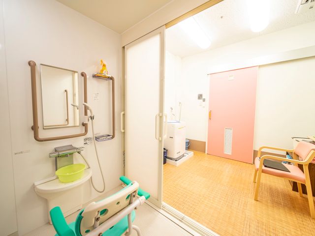 明るい浴室の設備 脱衣所 バリアフリー設計の浴室は、手すりや座浴椅子を完備し、安全にご利用いただけるよう工夫されています。この環境でのお仕事に、ぜひご興味をお持ちください。