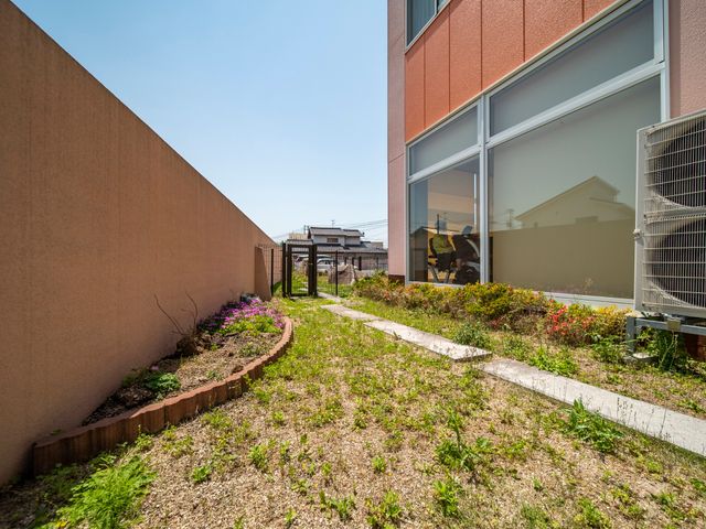 花壇付きの明るい中庭 庭園 日差しが注ぐ心地よい中庭です。季節の花々が感性を豊かにし、訪れる方々へ安らぎを提供しています。