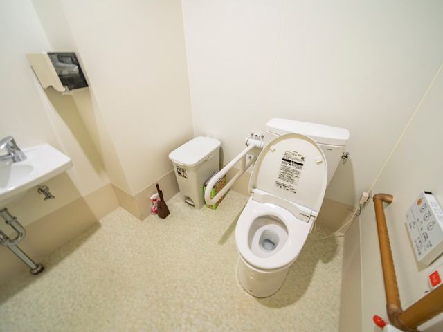 バリアフリー設計のトイレ 共同トイレ 手すりが設置された清潔感のあるトイレスペースです。安全かつ快適にご利用いただけるように配慮されています。