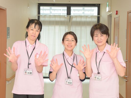 廊下で手を振るスタッフたち