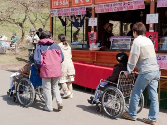 車椅子利用者と露店