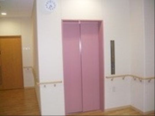 ピンクのエレベーターと廊下