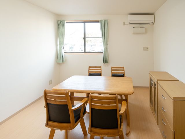 明るい居室のテーブルセット 居室 清潔感のあふれる居室で、テーブルと椅子が配置されており、家族や友人とのひとときを過ごせるように整えられています。