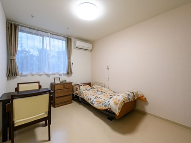居心地の良い居室 居室 ゆったりとしたベッドと、落ち着いた雰囲気の家具が配置されており、個々の生活スタイルに合わせた快適な空間です。