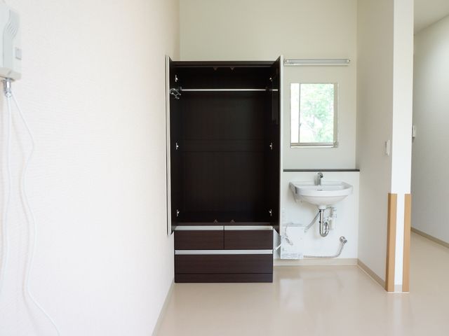 明るい居室の洗面台 クローゼット シンプルで清潔感のある部屋に洗面所が備わっています。窓から自然光が差し込む明るい空間です。