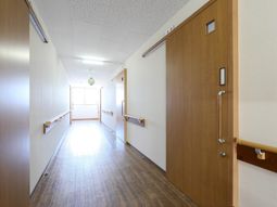 明るい通路と木目の扉