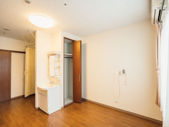 居室の洗面台とシャワー 居室 ゆったりとした洗面スペースが確保され、清潔感のある居室の一角です。利用者の方々の快適な日々を支える設備が整っています。