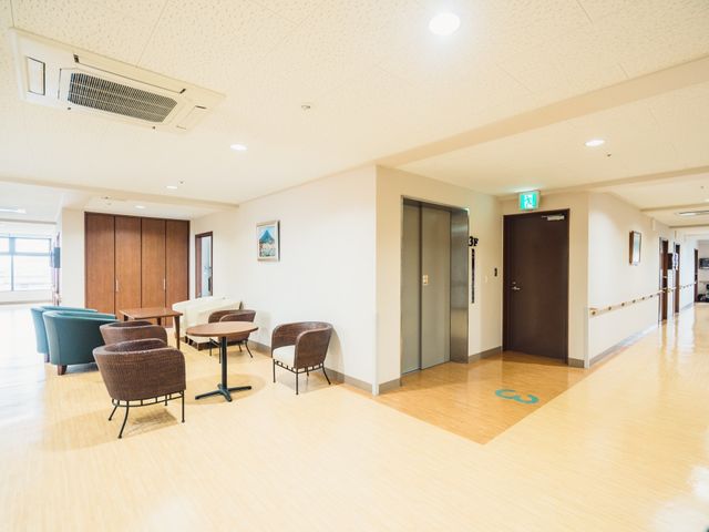 明るい廊下とリビングエリア 談話コーナー ゆったりとした椅子が配置された快適な共有スペースです。日々の生活の中で憩いの場としてご利用いただけます。