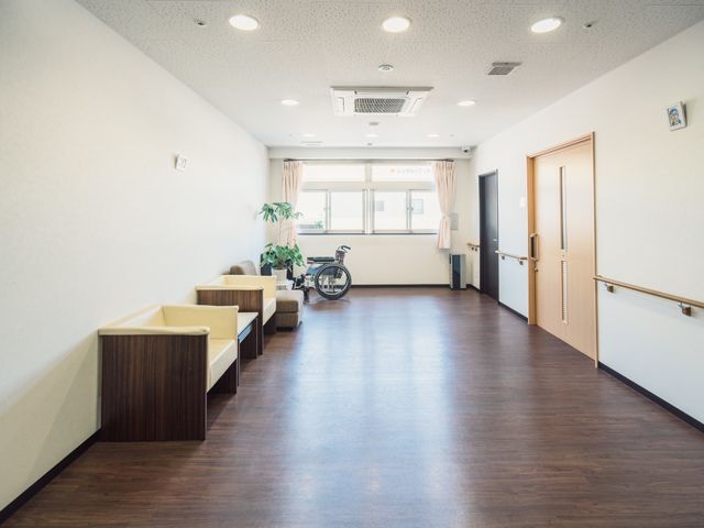 清潔な廊下の様子 廊下 明るく清潔感のある廊下では、落ち着いた色合いの椅子が配置され、静かな読書や休憩に適しています。