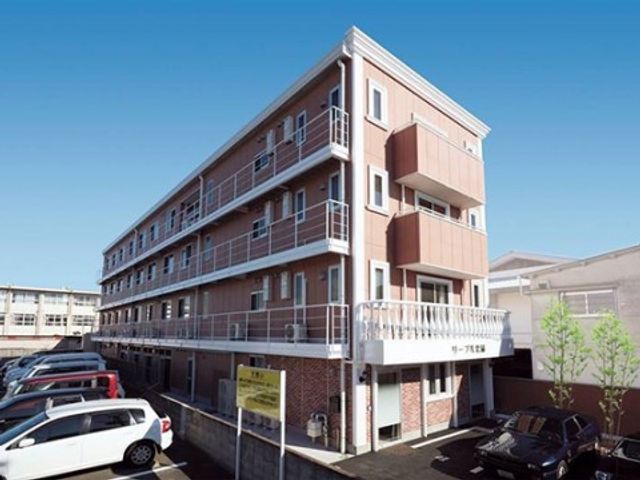 青空の下の清潔な外観 外観 手入れが行き届いた清潔感のある建物は、就業環境としても理想的です。駐車場完備で通勤も便利です。