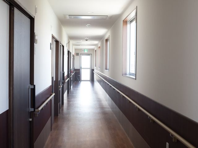 明るい廊下の風景 廊下 手すりが整備されたきれいな廊下です。落ち着いた色合いで、快適にお過ごしいただけます。