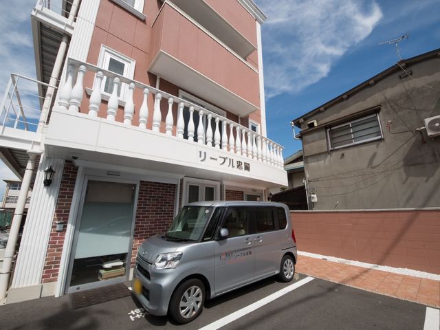 赤茶色の建物の外観 外観 暖かく迎えるエントランスは、ゆとりを感じさせる設計になっており、ここから新たな職場での一日が始まります。