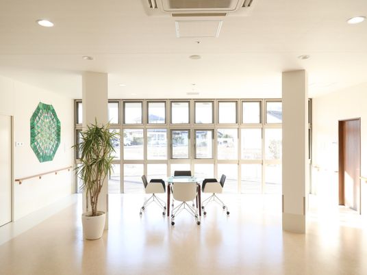 施設の写真 窓の多いスペースには、テーブルと椅子が設置されており、採光も十分なため、明るい空間で歓談することができる。