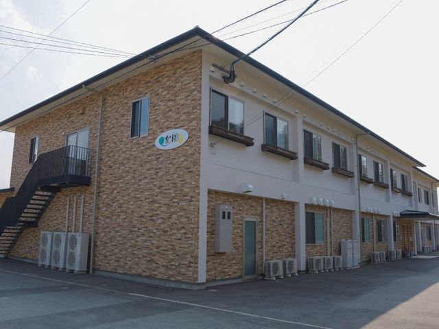 施設外観の建物 全体像 明るく清潔感のある外観です。建物は広々としており、安心して日々を過ごせるような印象を与えます。