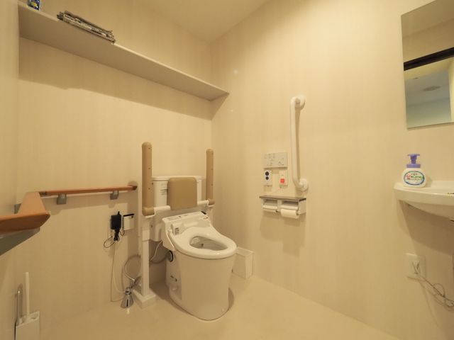 手すり付きのトイレ空間 トイレ 安全に配慮された設計のトイレ空間です。手すりや緊急呼び出しボタンがあり、安心してご利用いただけます。