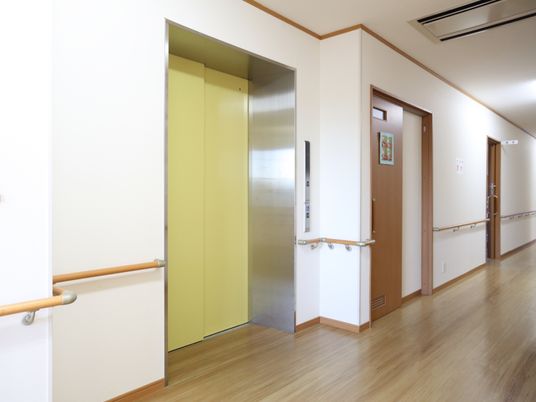 施設内にはバリアフリーのエレベーターを完備している。壁には操作パネルがあり、手すりが取り付けられている。