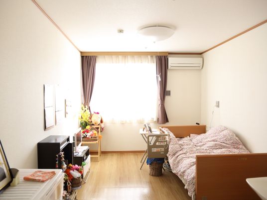 広々とした居室には、リクライニング機能がついた介護用ベッドが置かれている。また壁にはエアコンが取り付けられている。