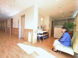 明るい廊下と座る人