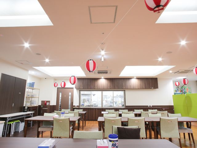 提灯が飾られたダイニングルーム リビング ゆったりとした食堂は提灯で飾り付けられ、明るく温かみのある雰囲気です。スタッフとして、この空間での食事のサポートを行えます。