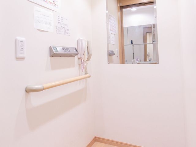 廊下と手すり エレベーター 安全かつ快適な移動を支援するため、手すりが設置された廊下が整備されています。壁には掲示物があり、情報共有にも配慮されています。
