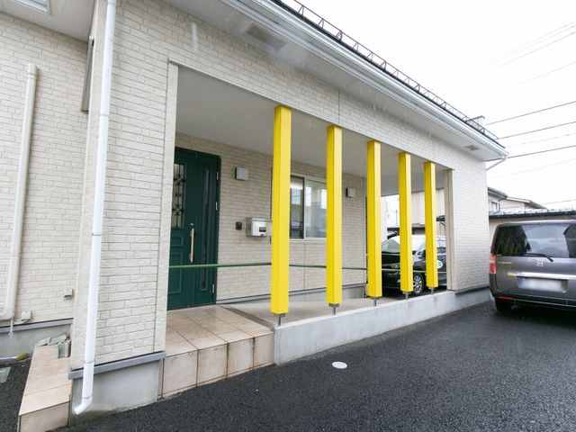 エントランスの明るい外観 外観 鮮やかな黄色の柱が特徴的なエントランスです。バリアフリー設計に配慮した段差の少ない入り口があります。