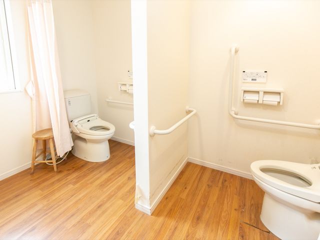 バリアフリーのトイレ トイレ 安全に配慮された室内で、手すりが設置された清潔なトイレスペースです。利用しやすい環境が整っています。