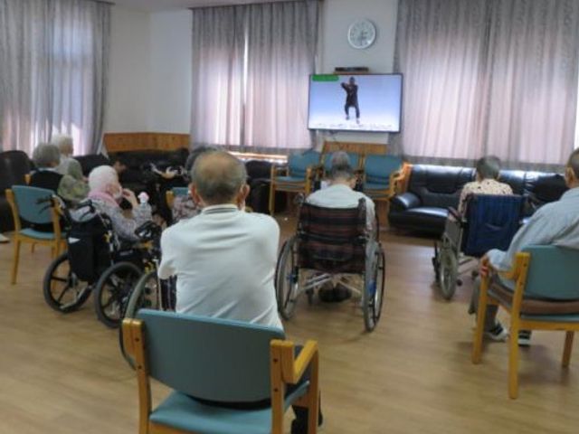 共有スペースで映像鑑賞 連携 ゆったりとした椅子が並び、大画面で映像鑑賞ができる共有スペースです。利用者の方々が楽しいひとときを過ごされています。