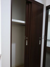 茶色い扉と白い壁の廊下